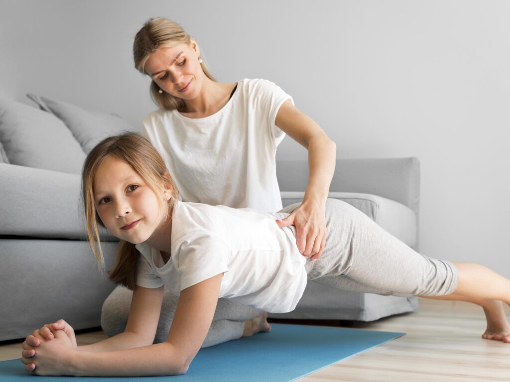 assisted planks Therapist assessing a girl's core muscles while she does a plank