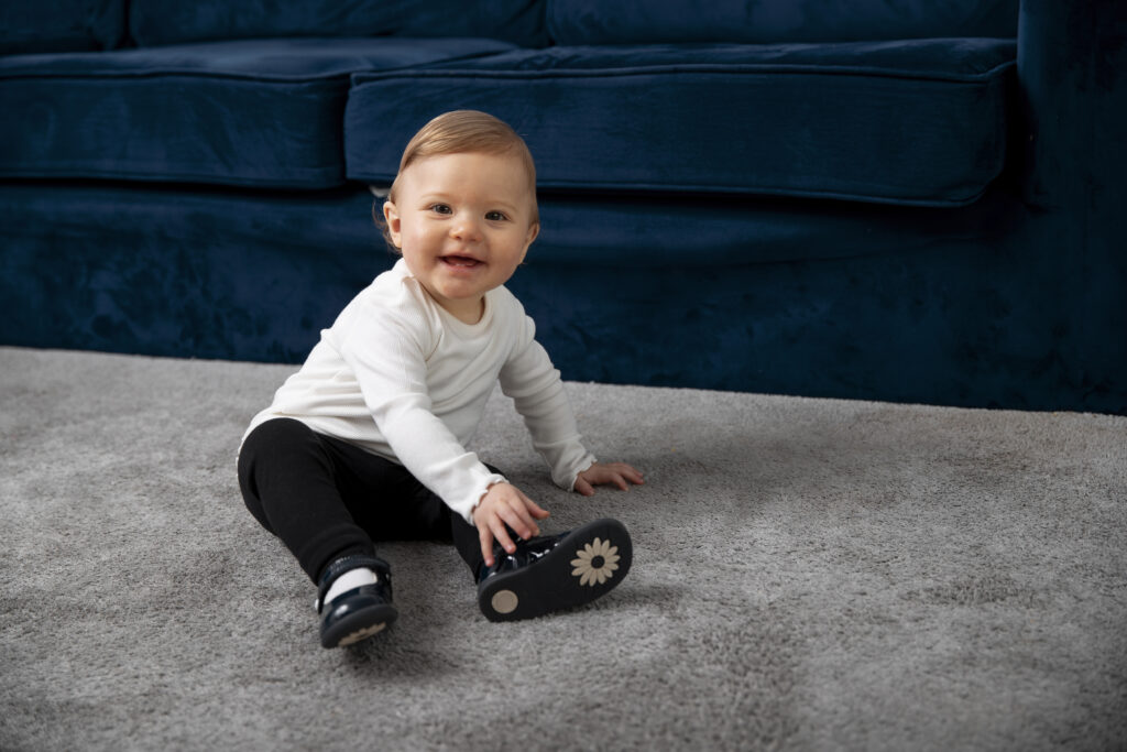 full-shot-smiley-kid-sitting-carpet